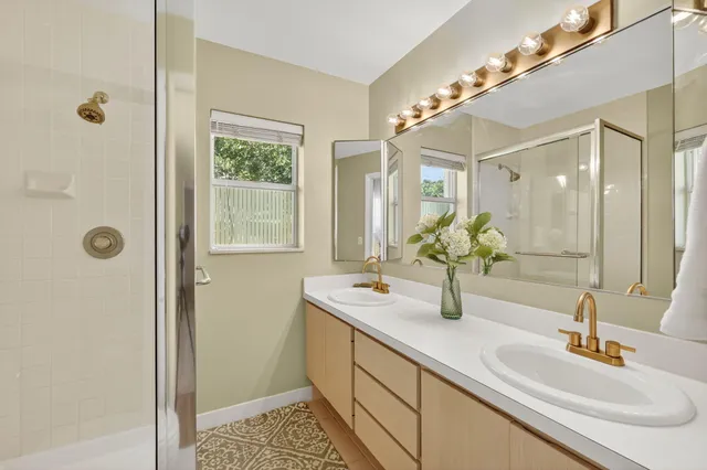 a bathroom with a sink toilet double vanity and shower