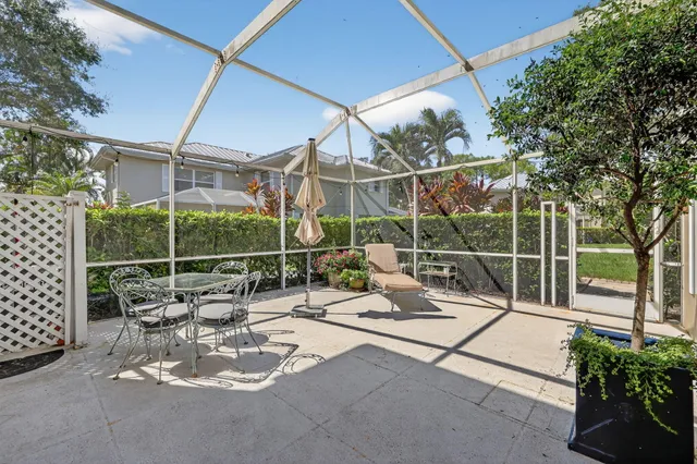 a view of a patio with a dining table and chairs with wooden fence