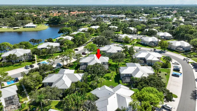 an aerial view of a house with yard lake and outdoor seating