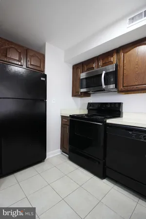 a kitchen with a refrigerator and a stove top oven