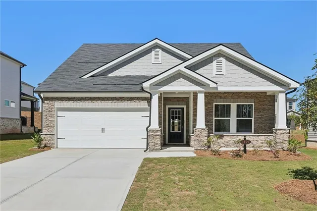 a front view of a house with a yard outdoor seating and garage