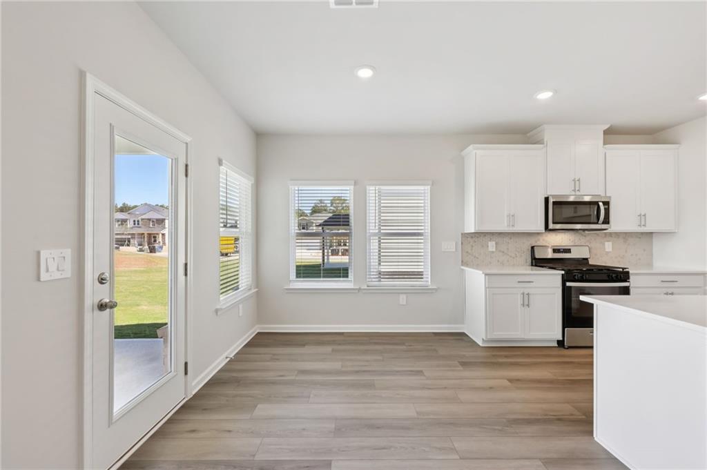 1499 High Fls Lane Grayson, GA 30017 - Photo 11 of 37 a kitchen with stainless steel appliances a refrigerator and a stove top oven