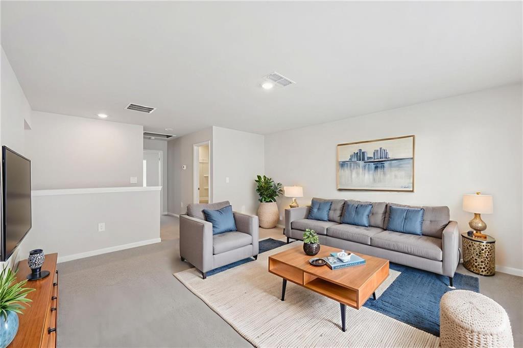 1499 High Fls Lane Grayson, GA 30017 - Photo 30 of 37 a living room with furniture a rug and a flat screen tv