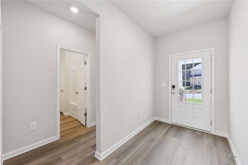 1499 High Fls Lane Grayson, GA 30017 - Photo 3 of 37 an empty room with wooden floor and windows