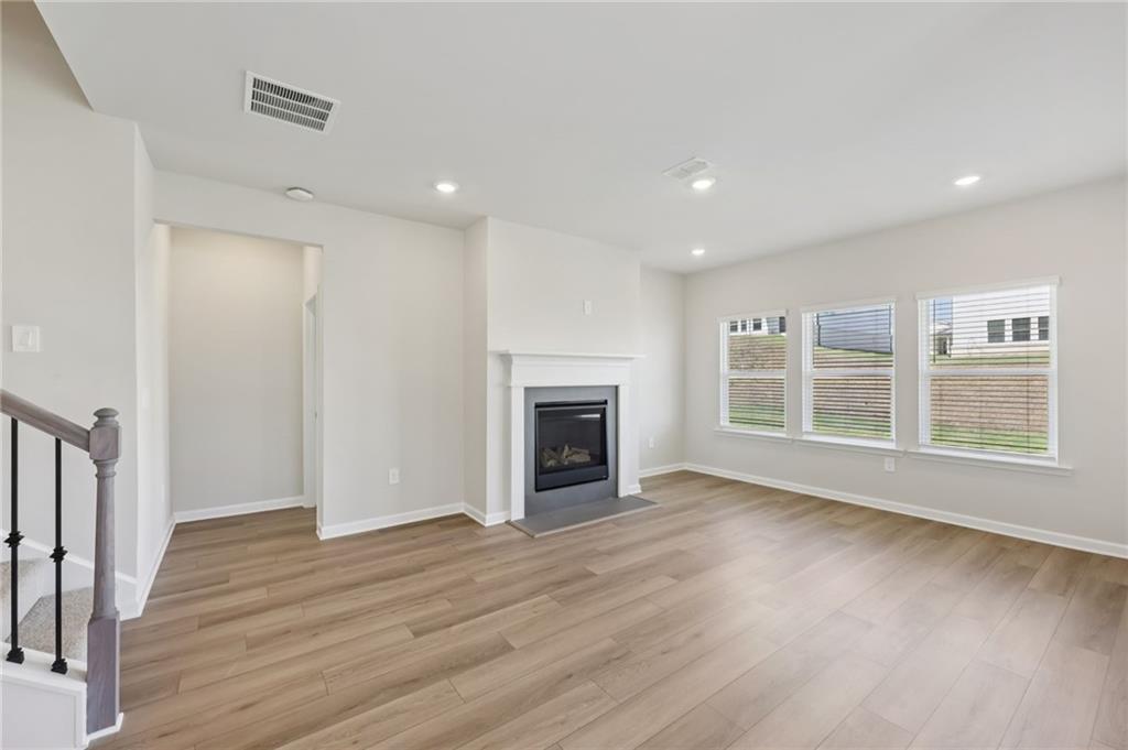 1499 High Fls Lane Grayson, GA 30017 - Photo 4 of 37 a view of an empty room with wooden floor fireplace and a window