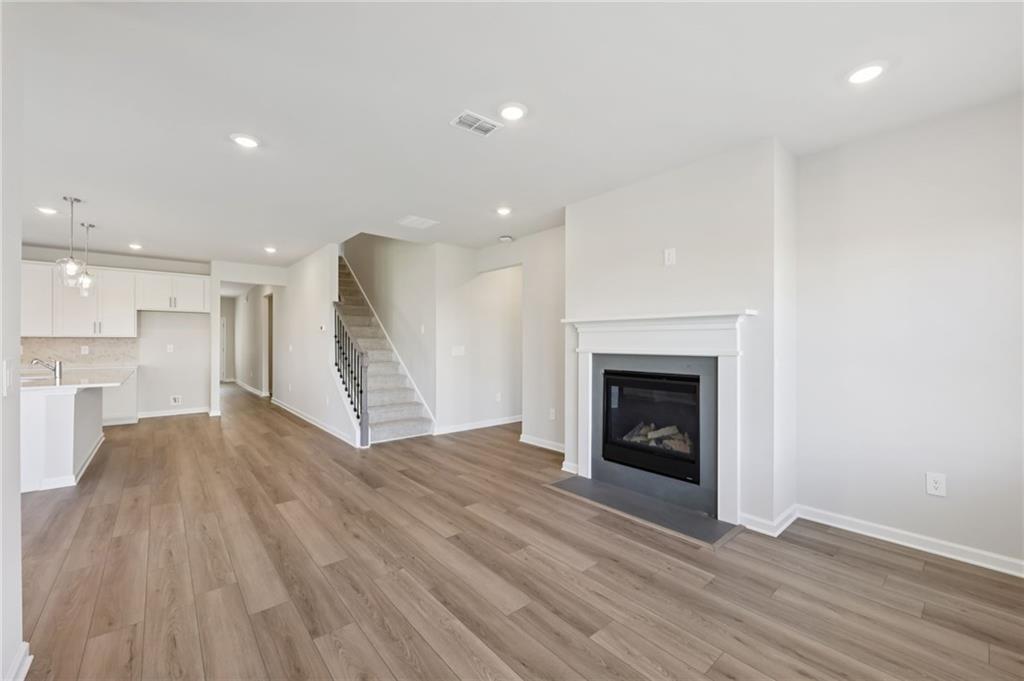 1499 High Fls Lane Grayson, GA 30017 - Photo 7 of 37 a view of an empty room with wooden floor fire place and kitchen view