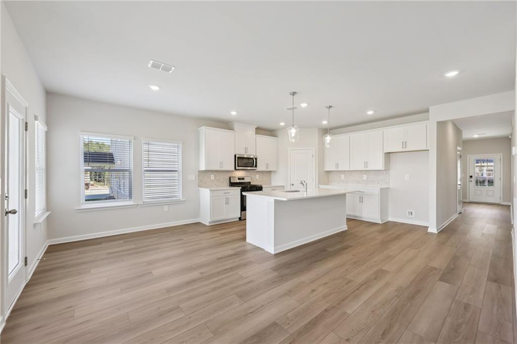 1499 High Fls Lane Grayson, GA 30017 - Photo 10 of 37 a view of kitchen with kitchen island wooden floors wooden floor and center island