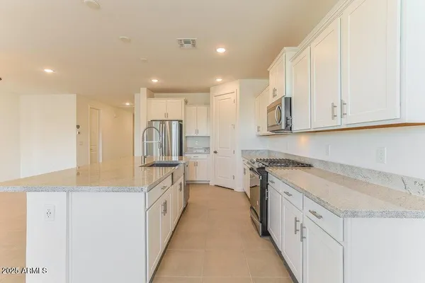 a kitchen with stainless steel appliances granite countertop a sink and a stove