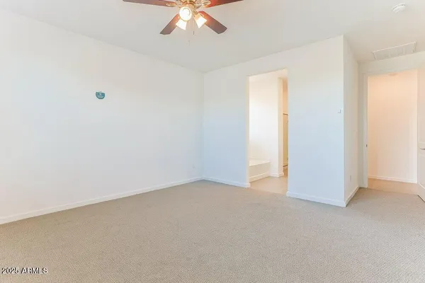 an empty room with a chandelier fan
