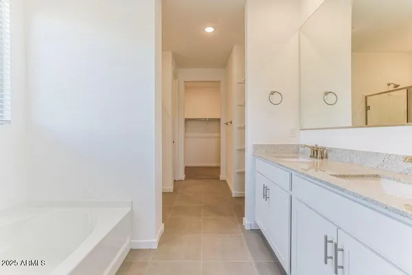 a bathroom with a granite countertop sink a mirror and a bathtub
