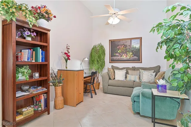 a living room with furniture a bookshelf and a potted plant