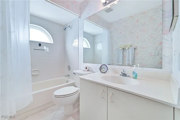 a bathroom with a toilet a sink a bath tub and a mirror