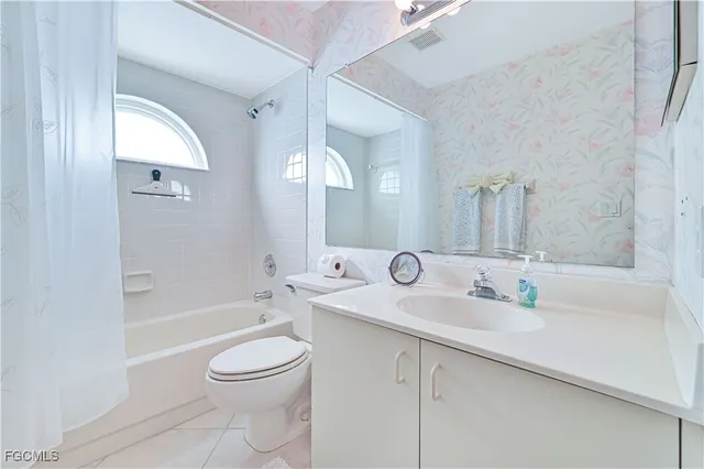 a bathroom with a toilet a sink a bath tub and a mirror