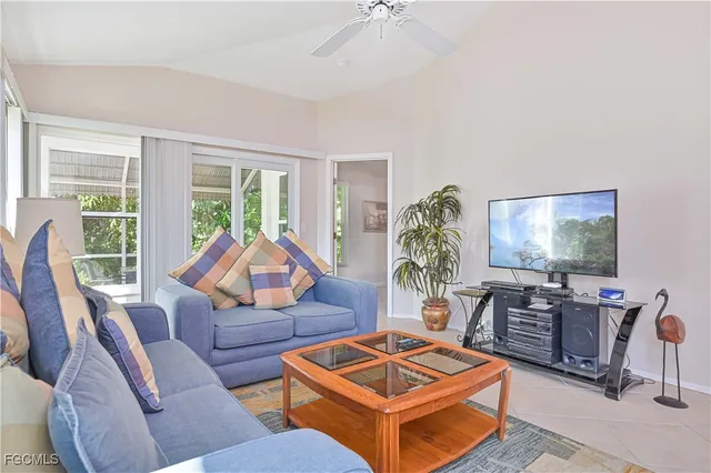 a living room with furniture a flat screen tv and a large window