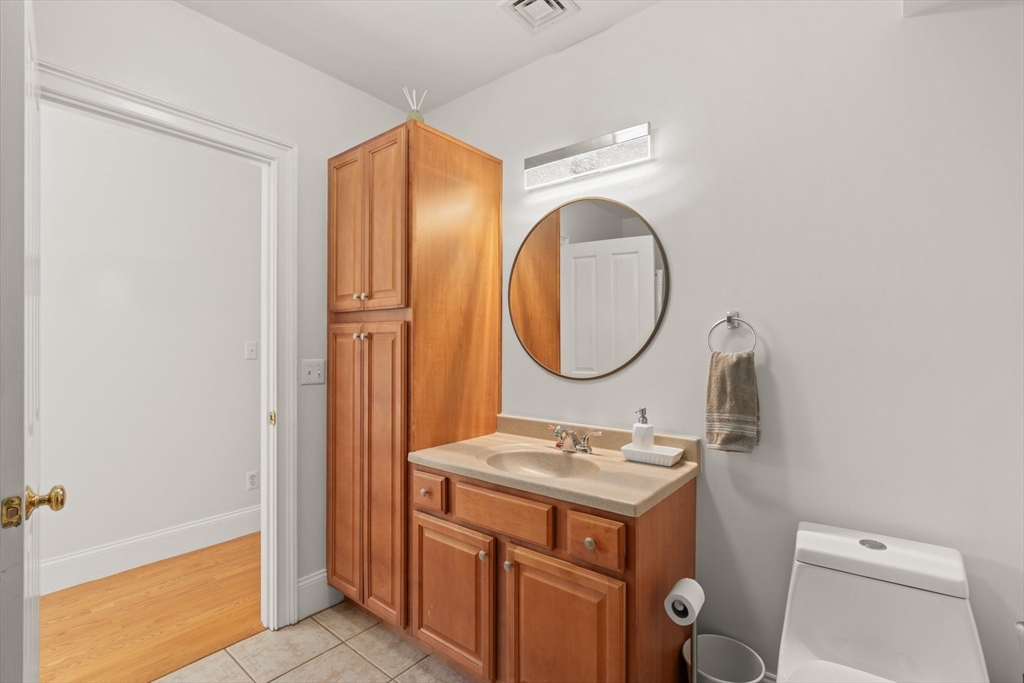 17 Robbins Street, Unit 22 Waltham, MA 02453 - Photo 13 of 27 a bathroom with a toilet a sink and a mirror