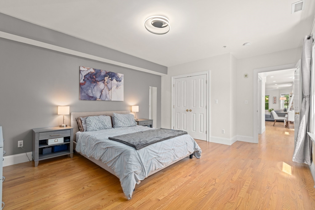 17 Robbins Street, Unit 22 Waltham, MA 02453 - Photo 16 of 27 a spacious bedroom with a bed and a painting on the wall