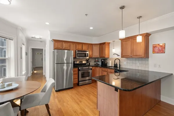 a kitchen with stainless steel appliances granite countertop a sink refrigerator and cabinets