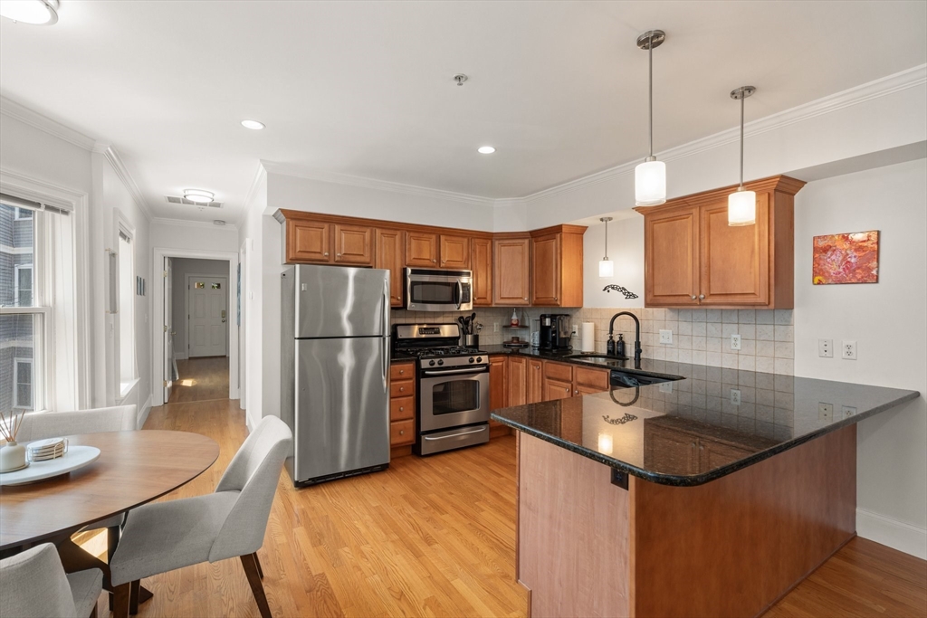 17 Robbins Street, Unit 22 Waltham, MA 02453 - Photo 5 of 27 a kitchen with stainless steel appliances granite countertop a sink refrigerator and cabinets