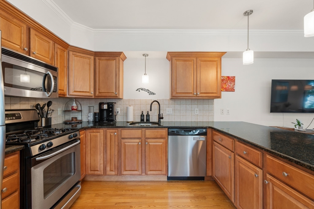 17 Robbins Street, Unit 22 Waltham, MA 02453 - Photo 7 of 27 a kitchen with stainless steel appliances granite countertop a sink stove and microwave