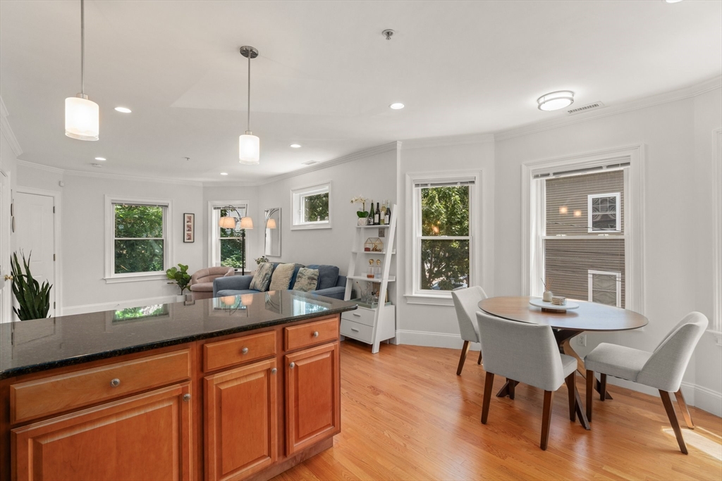 17 Robbins Street, Unit 22 Waltham, MA 02453 - Photo 8 of 27 a dining hall with stainless steel appliances granite countertop wooden floor a dining table and chairs