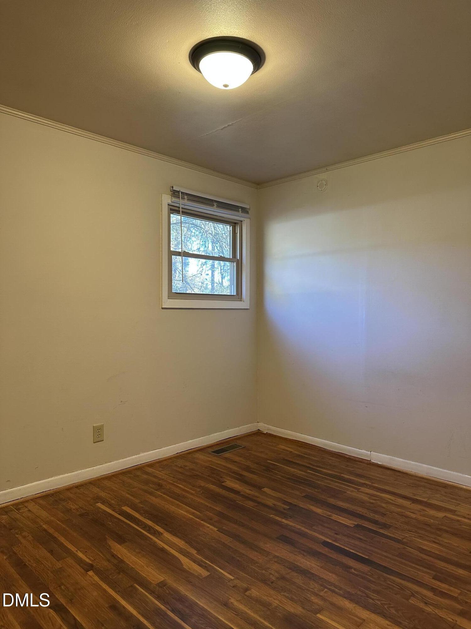 717 Crosby Road Durham, NC 27704 - Photo 11 of 15 an empty room with wooden floor and windows