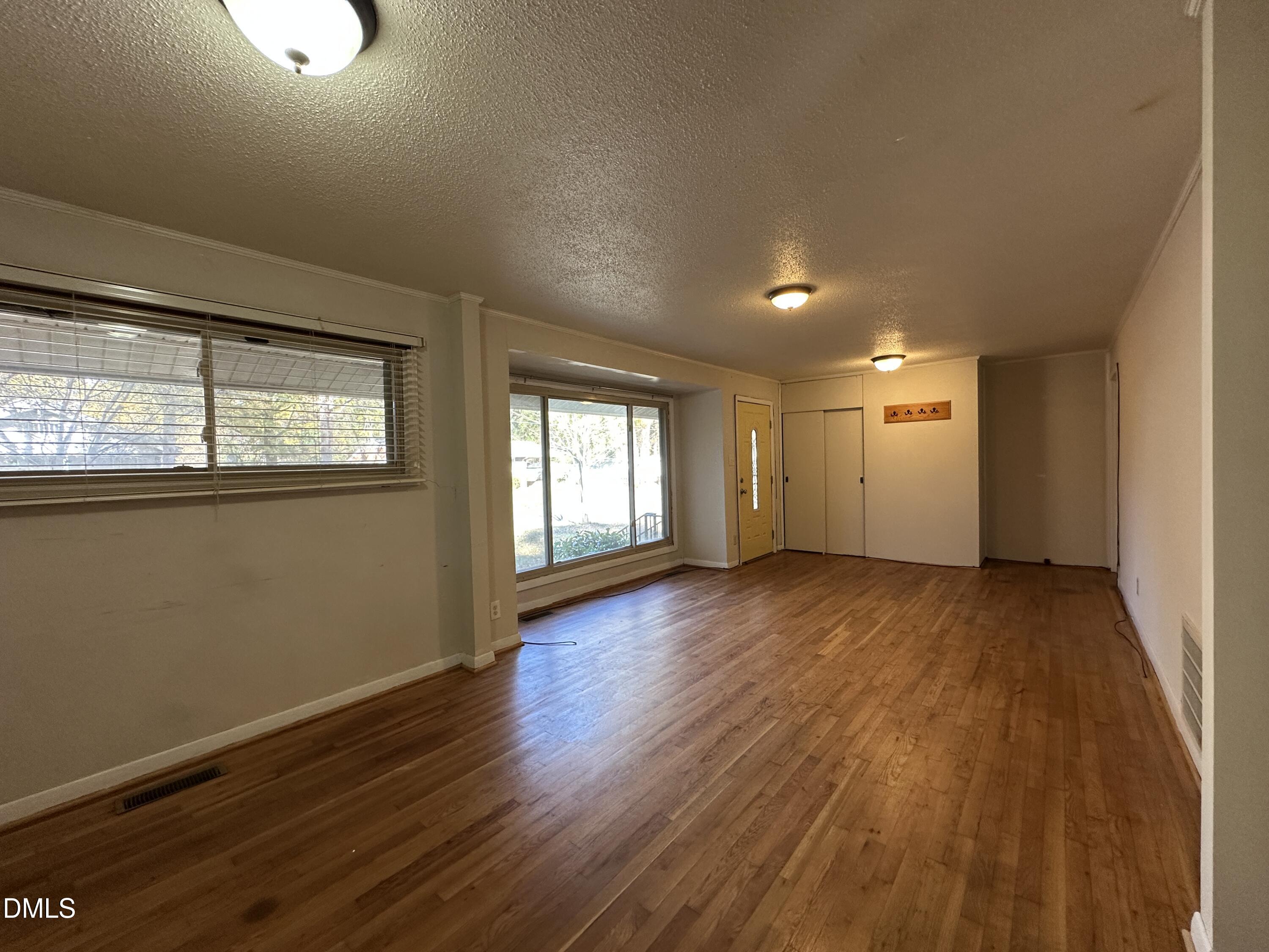 717 Crosby Road Durham, NC 27704 - Photo 5 of 15 a view of an empty room with wooden floor and a window