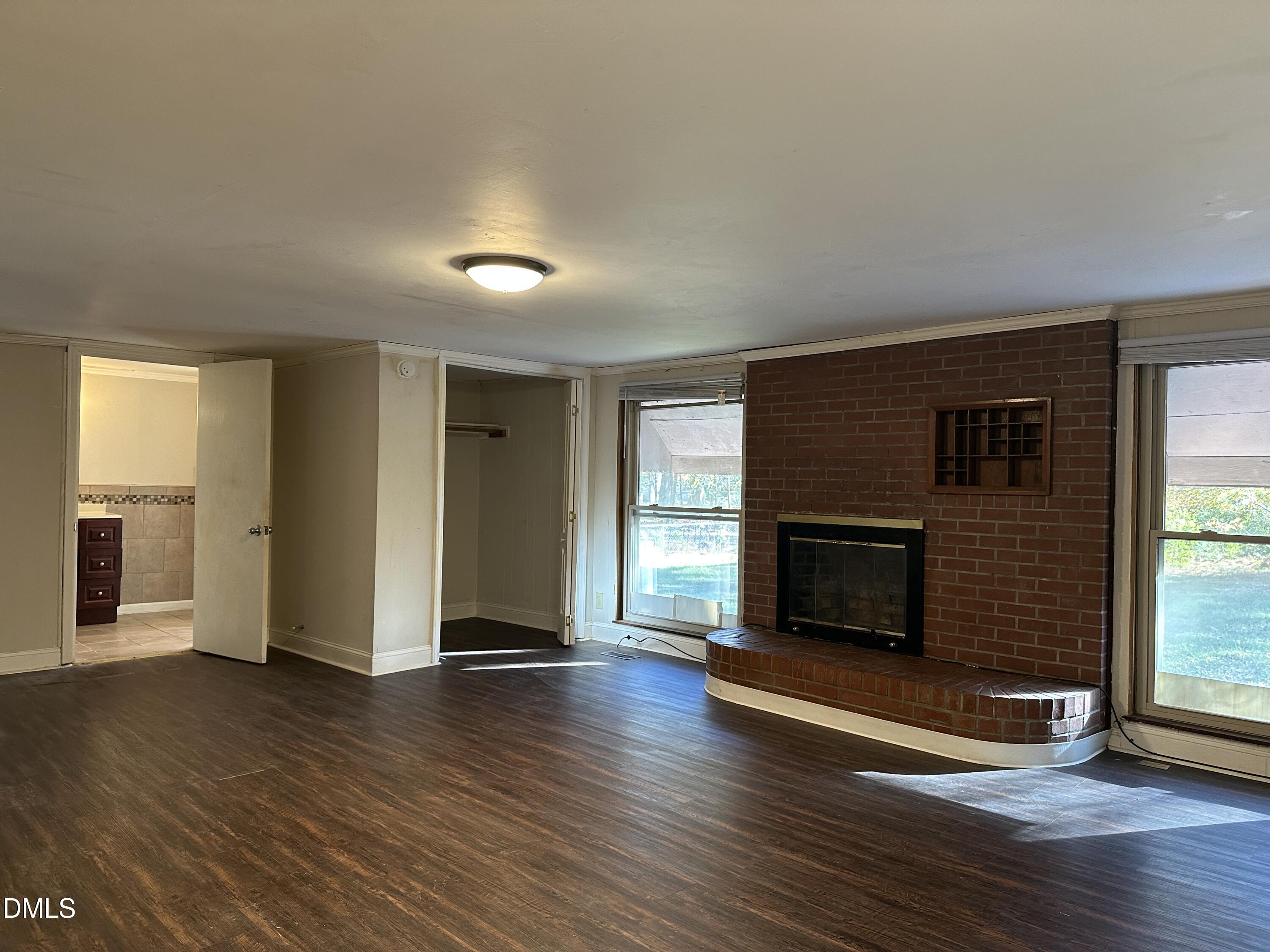 717 Crosby Road Durham, NC 27704 - Photo 6 of 15 a view of a livingroom with wooden floor and a fireplace
