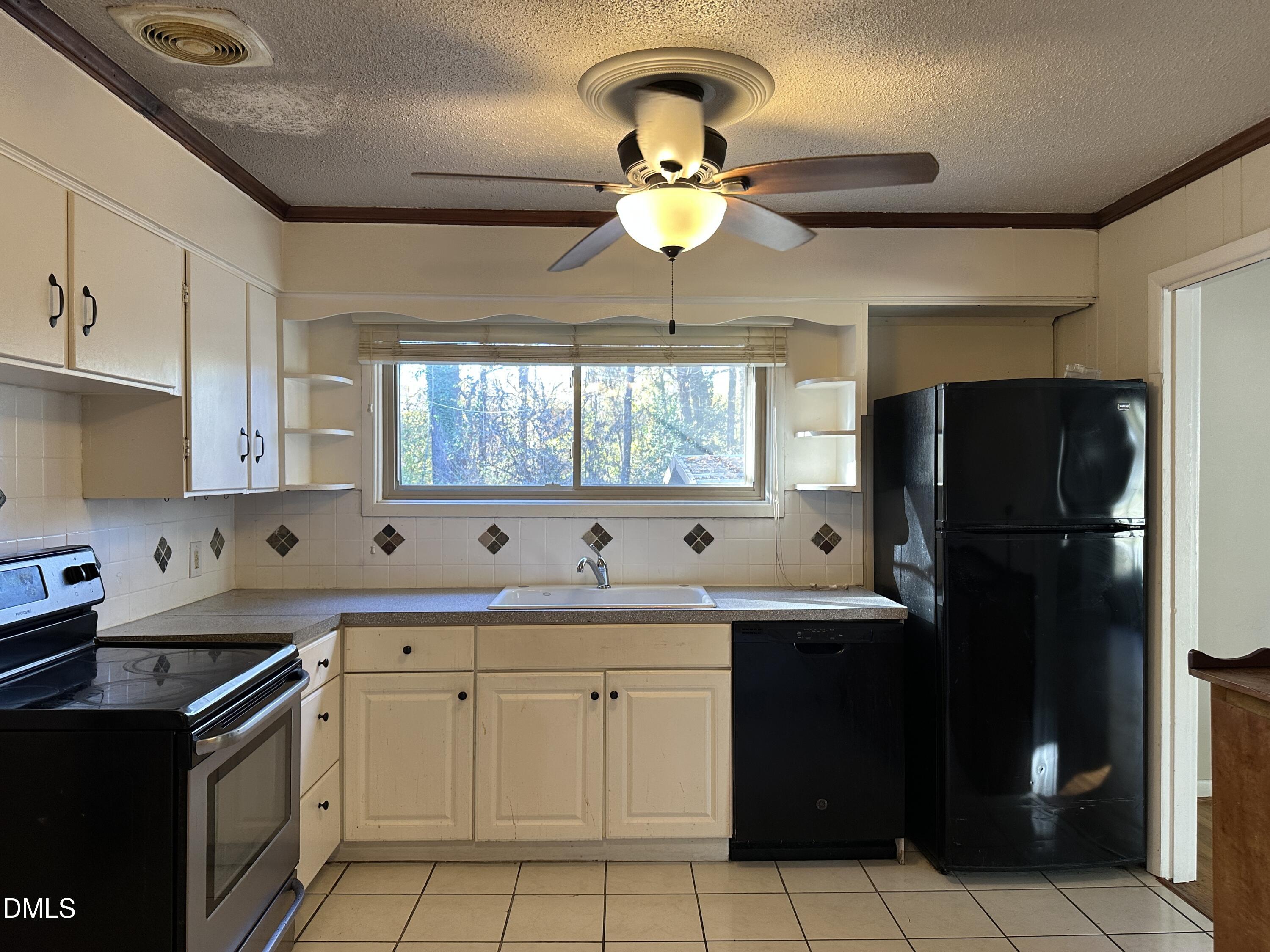 717 Crosby Road Durham, NC 27704 - Photo 7 of 15 a kitchen with a sink a stove cabinets and a window