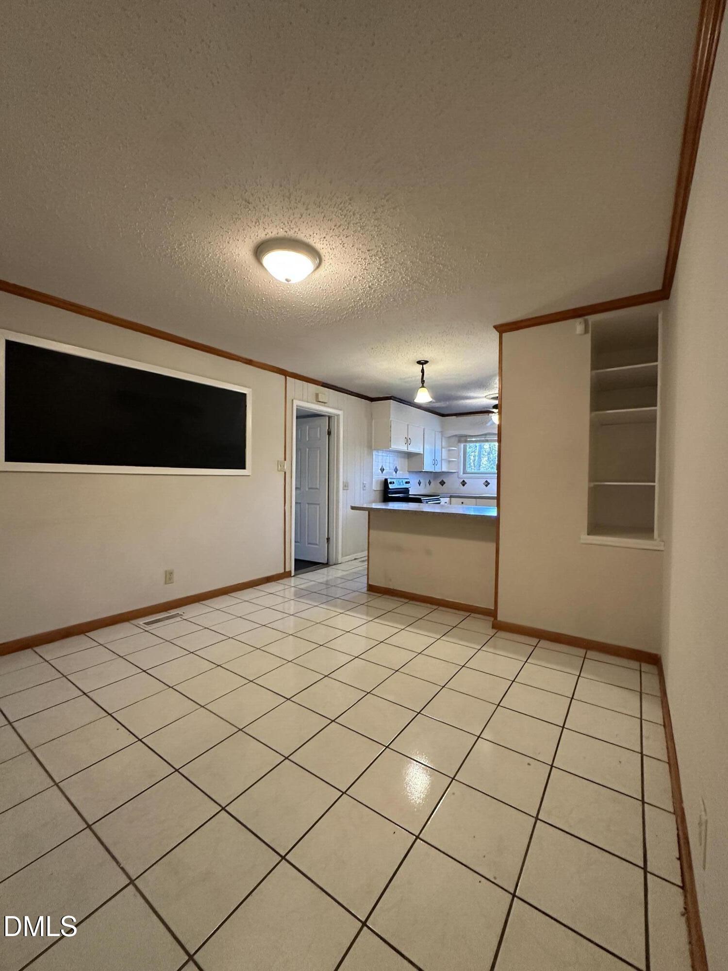 717 Crosby Road Durham, NC 27704 - Photo 8 of 15 a view of a livingroom with an empty space and a fireplace