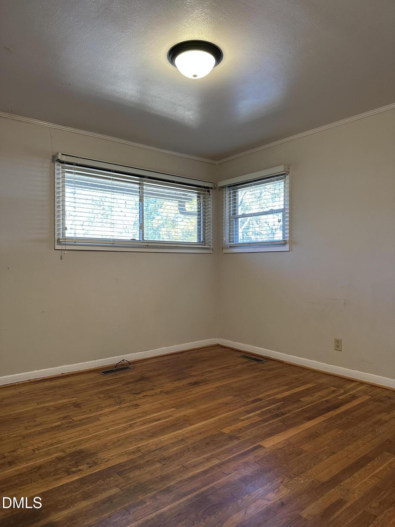 717 Crosby Road Durham, NC 27704 - Photo 9 of 15 a view of an empty room with wooden floor and a window