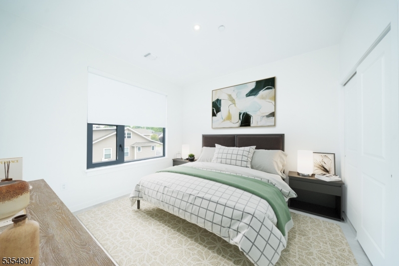 12 River Road, Unit 205 Fair Lawn, NJ 07410 - Photo 4 of 9 a bedroom with a bed and a painting on the wall