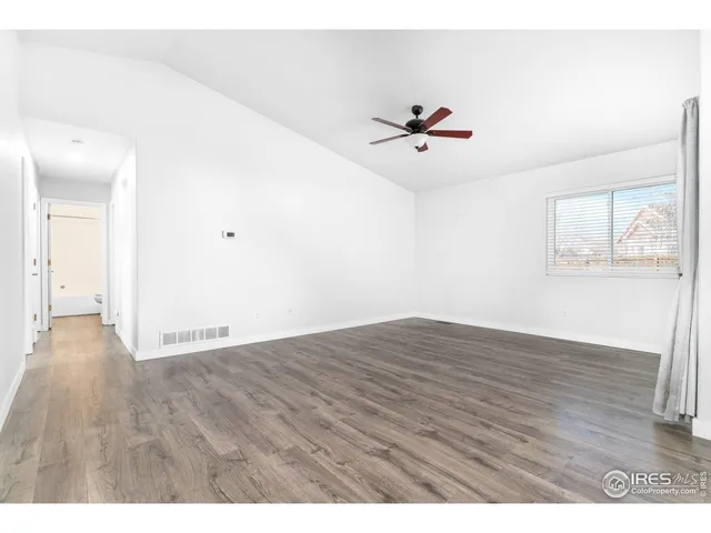 a view of a room with wooden floor and ceiling fan