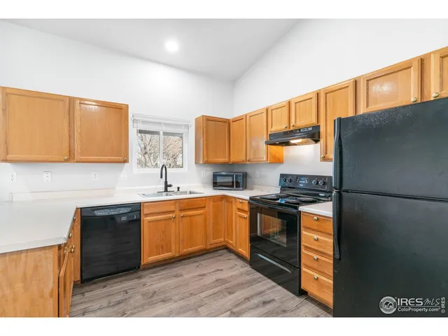 a kitchen with stainless steel appliances granite countertop a refrigerator a sink dishwasher a stove with wooden cabinets