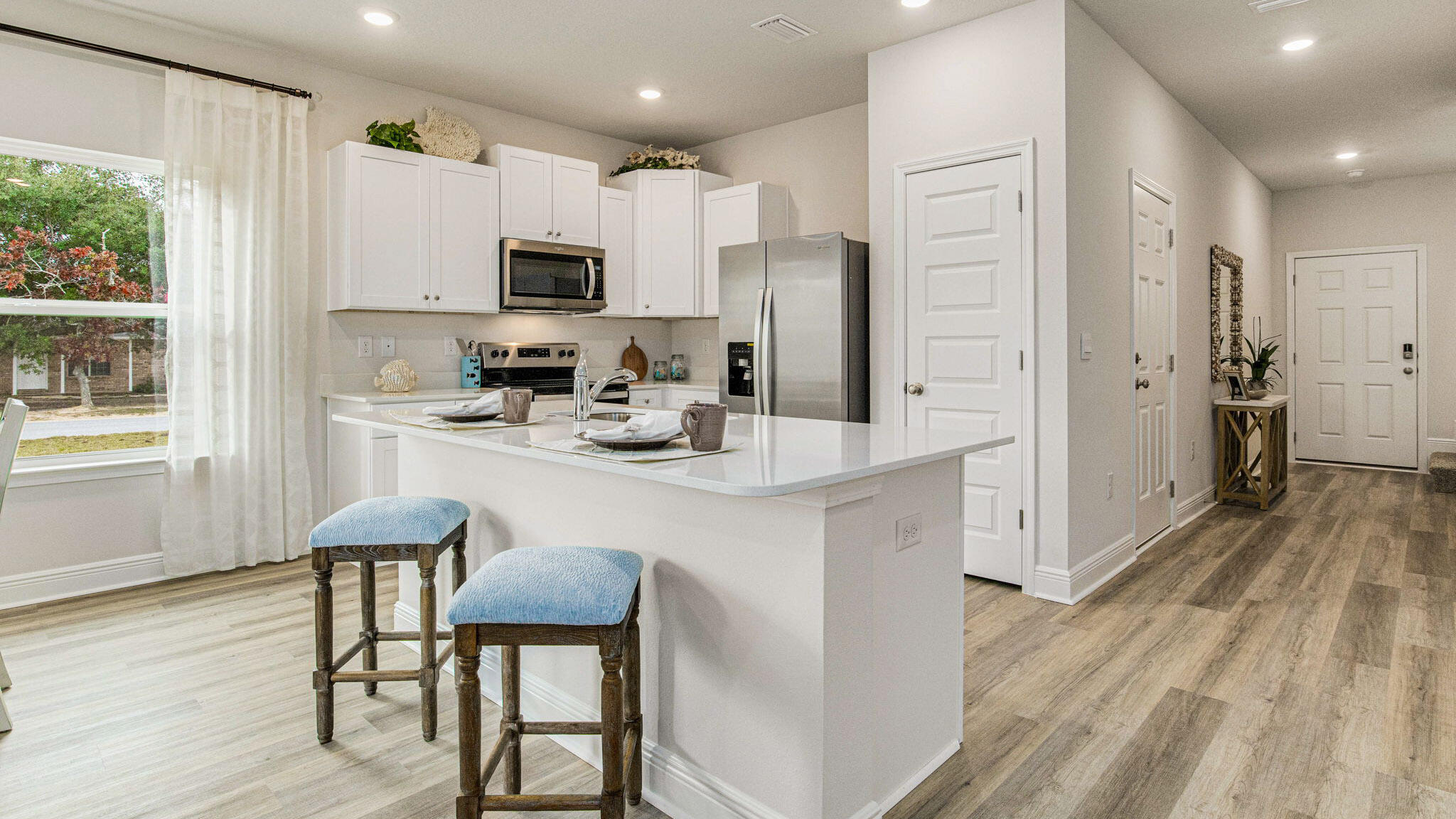 8463 Midtown Court Navarre, FL 32566 - Photo 1 of 27 a kitchen with stainless steel appliances granite countertop a refrigerator a stove microwave and white cabinets with wooden floor