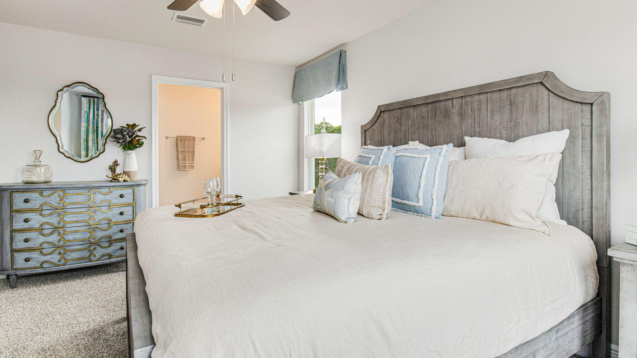 8463 Midtown Court Navarre, FL 32566 - Photo 16 of 27 a spacious bedroom with a bed a dresser and a chandelier