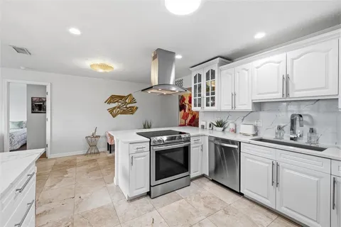 a kitchen with a stove sink and cabinets
