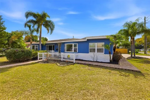 a view of a swimming pool with plants and palm trees