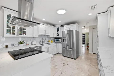 a kitchen with stainless steel appliances granite countertop a refrigerator a stove and a sink