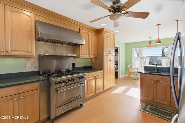 a kitchen with stainless steel appliances granite countertop a stove a sink and a refrigerator