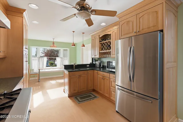 a kitchen with stainless steel appliances a refrigerator a sink and white cabinets
