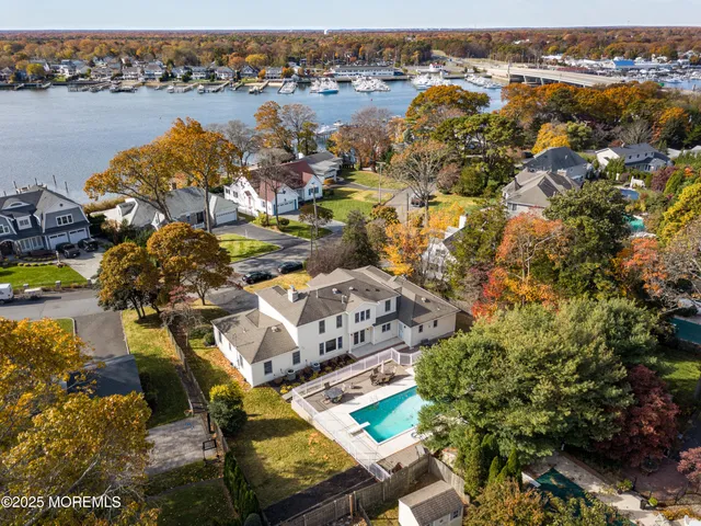 an aerial view of residential houses with outdoor space and lake view
