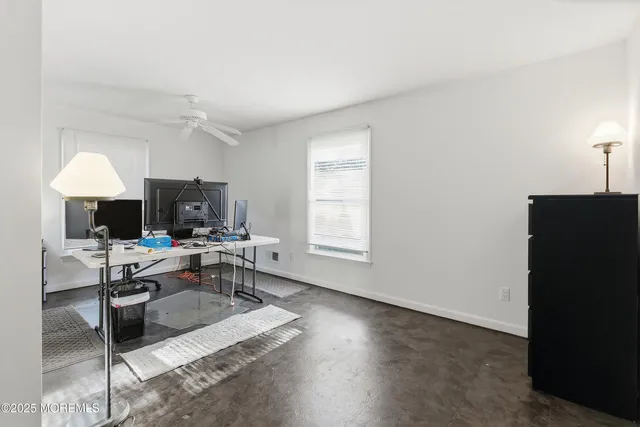 a view of a workspace with furniture and a window
