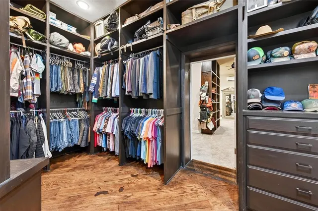 a view of walk in closet with clothes and shoes