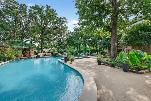 a view of a swimming pool with outdoor seating and plants