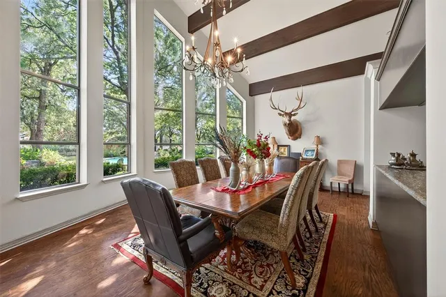 a dining room with furniture a chandelier and wooden floor