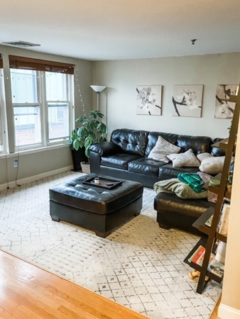 122 Tudor Street, Unit D Boston, MA 02127 - Photo 1 of 8 a living room with furniture and a table