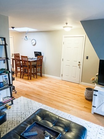 122 Tudor Street, Unit D Boston, MA 02127 - Photo 4 of 8 a room with wooden floor and furniture