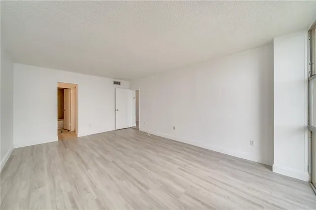 a view of an empty room and wooden floor