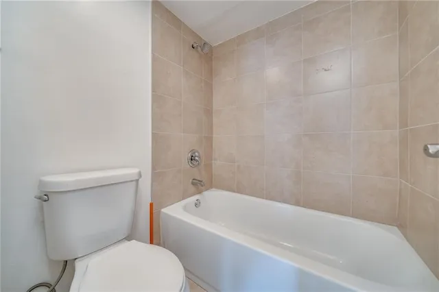 a white toilet sitting next to a bath tub