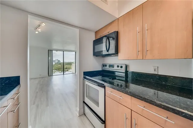 a kitchen with stainless steel appliances granite countertop a stove a sink and a microwave